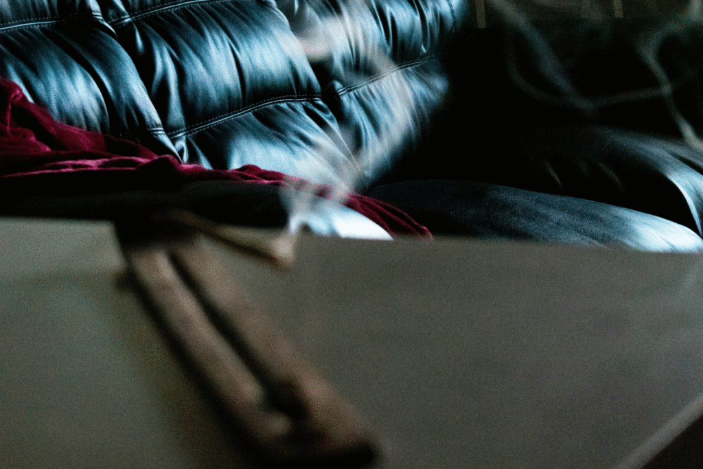 dark image of two blurry lit joints on a counter with a couch in focus in the background