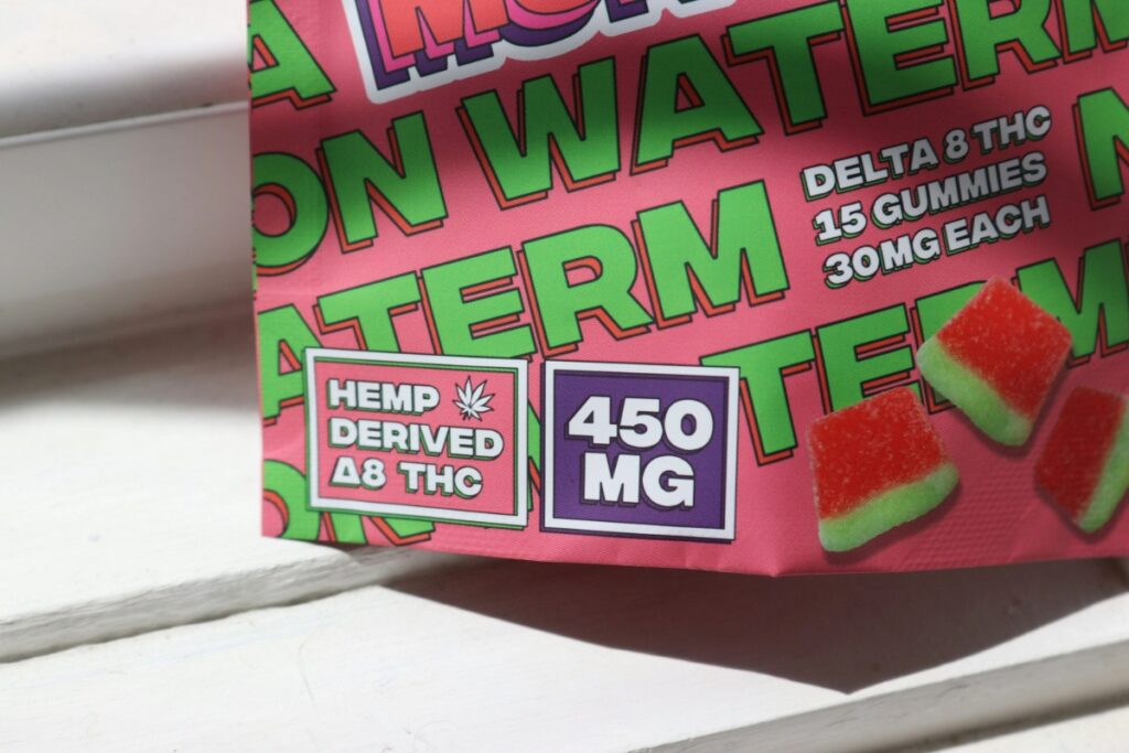 Close-up of brightly colored Delta 8 THC edible gummy packaging labeled 450 MG, illustrating the appealing but potentially unregulated products found in a fake or unlicensed dispensary.