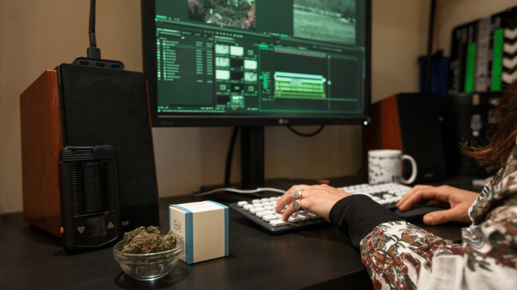 - Nature Med Dispensaries A video editor working on a computer at a desk with a dry herb vaporizer and a bowl of cannabis flower.