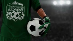 Soccer goalkeeper in a green jersey holding a soccer ball, stadium lights in the background.