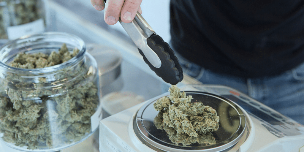 - Nature Med Dispensaries - Nature Med Dispensaries jars of cannabis nugs being weighed by someone
